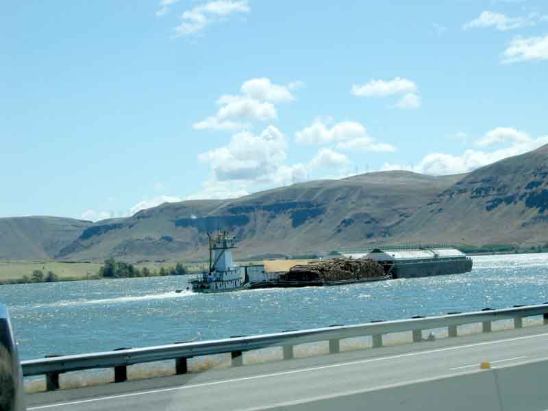 barge and tug going up river